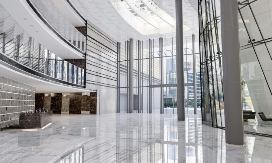 Modern office lobby with polished marble floors and glass walls in a commercial building